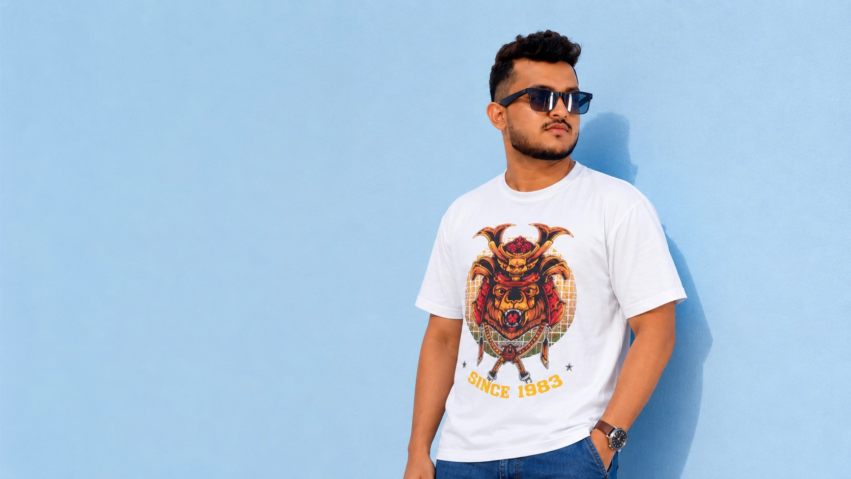 Golden Eagle campaign — model in the samurai graphic tee against a blue wall